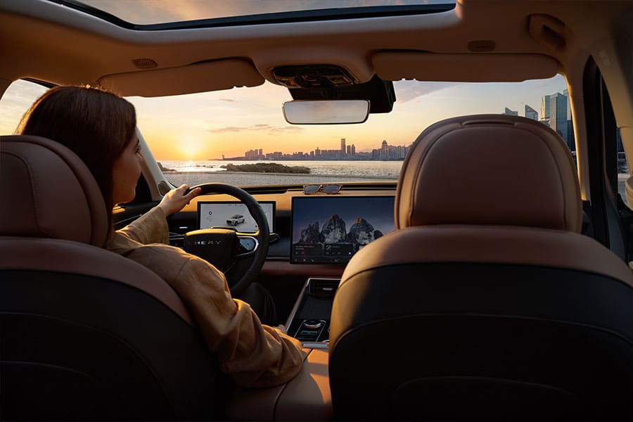 אישה נוהגת ברכב פלאג-אין הייבריד של צ'רי